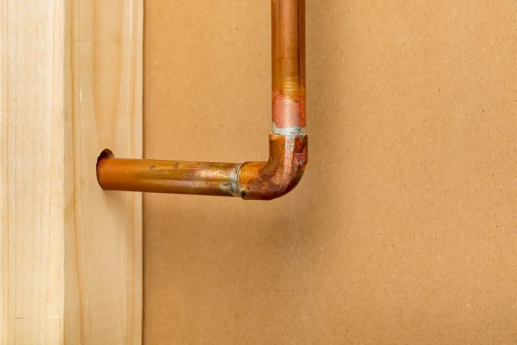 Copper water plumbing pipe inside wall. Pipe repair, maintenance and remodeling concept.