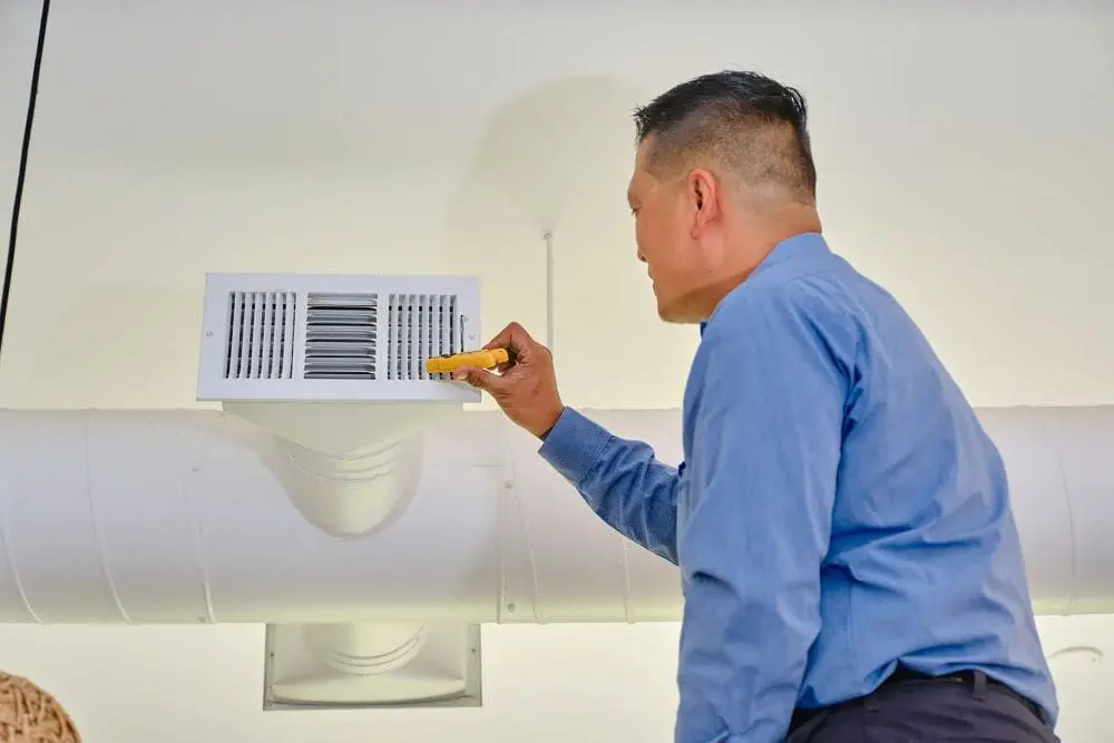 Day & Night Air Conditioning, Heating, and Plumbing technician inspecting an indoor HVAC air vent in Scottsdale, Arizona using a handheld testing tool. The scene represents commercial HVAC services in Scottsdale AZ, including system inspection, maintenance, and airflow testing for business properties. The visible ductwork and vent system highlight real service work focused on air distribution and system performance. Customers in Scottsdale can contact Day & Night Air Conditioning, Heating, and Plumbing at (602) 584-7758 for commercial HVAC repair, installation, and maintenance services.