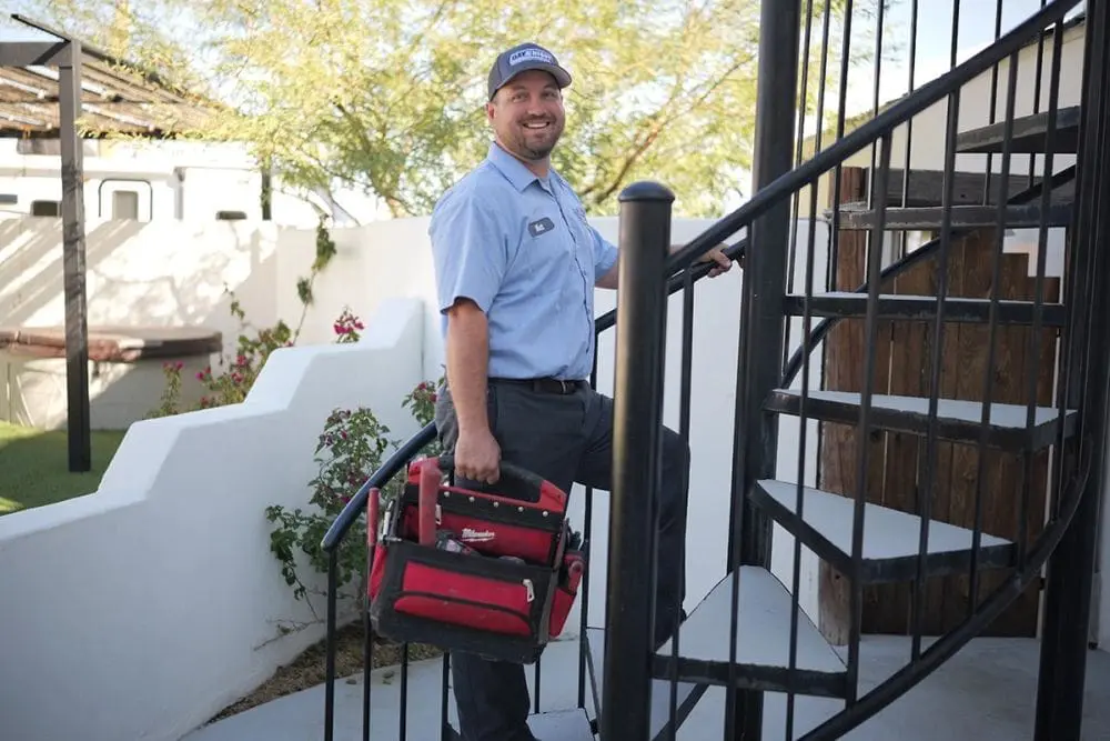 Day & Night Air Conditioning, Heating, and Plumbing technician walking up outdoor stairs in Scottsdale, Arizona while carrying a tool bag for service work. The scene represents commercial HVAC in Scottsdale AZ, where technicians travel to properties to perform system repair, installation, and maintenance. The technician’s tools indicate readiness for HVAC diagnostics, inspections, and service tasks. Customers in Scottsdale can contact Day & Night Air Conditioning, Heating, and Plumbing at (602) 584-7758 for commercial HVAC services and support.
