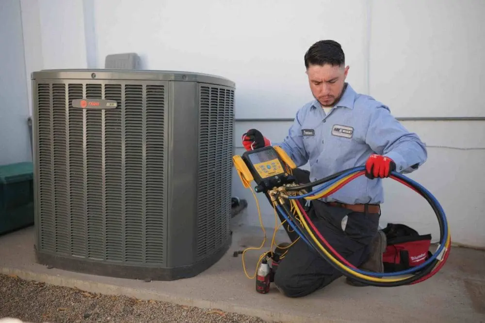 A Day & Night Air Conditioning, Heating and Plumbing technician performs Commercial AC Maintenance Scottsdale AZ service on a large outdoor air conditioning unit. The technician uses digital diagnostic equipment and refrigerant gauges to inspect cooling system performance and operating pressures. This commercial HVAC maintenance visit helps reduce breakdowns, improve energy efficiency, and support reliable cooling during Scottsdale's extreme summer temperatures