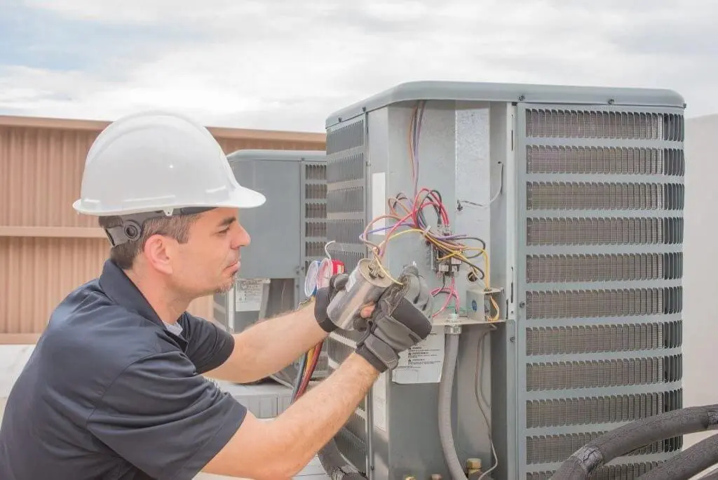 A commercial HVAC technician performs Commercial AC Maintenance Scottsdale AZ service on a rooftop air conditioning system. The technician inspects electrical components, wiring connections, and cooling equipment to verify proper operation and system performance. This preventative maintenance service helps Scottsdale businesses reduce equipment failures, improve cooling efficiency, and support reliable indoor comfort during Arizona's long cooling season. Day & Night Air Conditioning, Heating and Plumbing provides commercial HVAC maintenance, repair, and installation services throughout Scottsdale, Arizona.