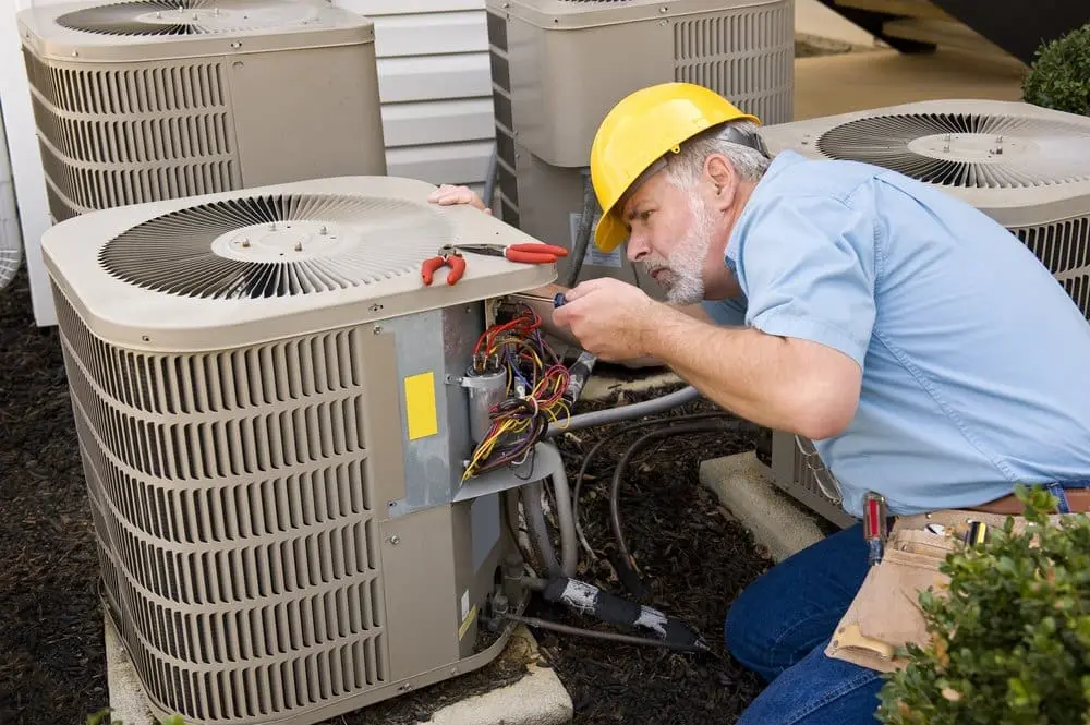 A Day & Night Air Conditioning, Heating and Plumbing technician performs Emergency AC Repair in Peoria, AZ on an outdoor residential air conditioning system. The image shows the technician inspecting electrical wiring and cooling system components inside an open condenser unit while diagnosing an equipment problem. Emergency air conditioner repair helps restore cooling quickly when a system stops working or produces unusual sounds during Arizona's hottest months. Day & Night Air Conditioning, Heating and Plumbing provides emergency AC repair, troubleshooting, and cooling system service throughout Peoria, Arizona. Homeowners can call (602) 584-7758 for fast assistance with AC breakdowns, electrical issues, and cooling performance problems.