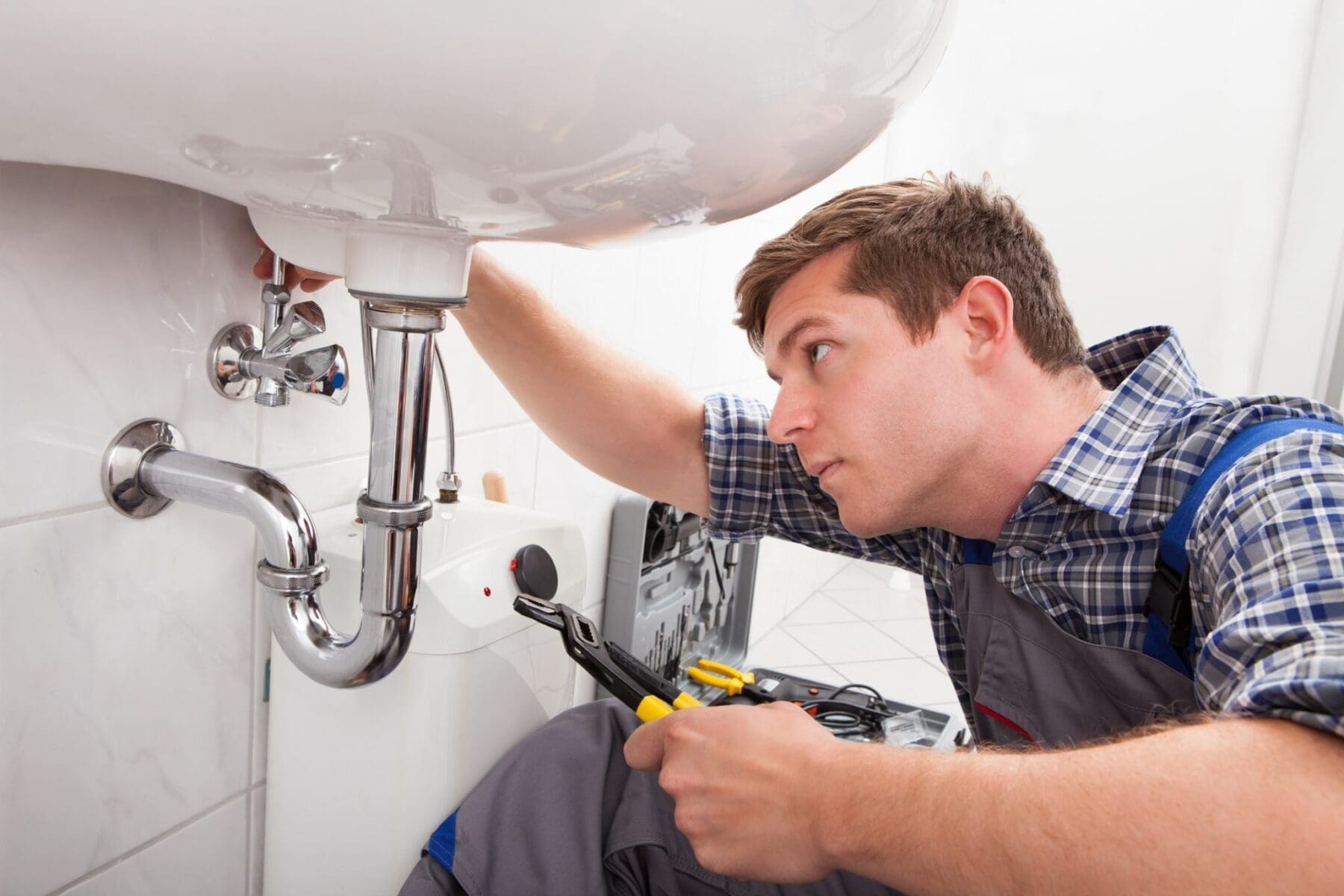 Plumber fixing a sink in bathroom Phoenix Plumbing Maintenance, Plumber Fixing Sink