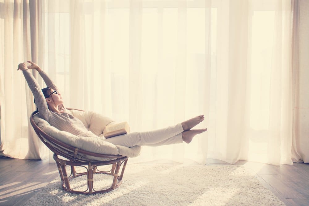 young woman relaxing and lounging in chair in comfortable home-day and night air